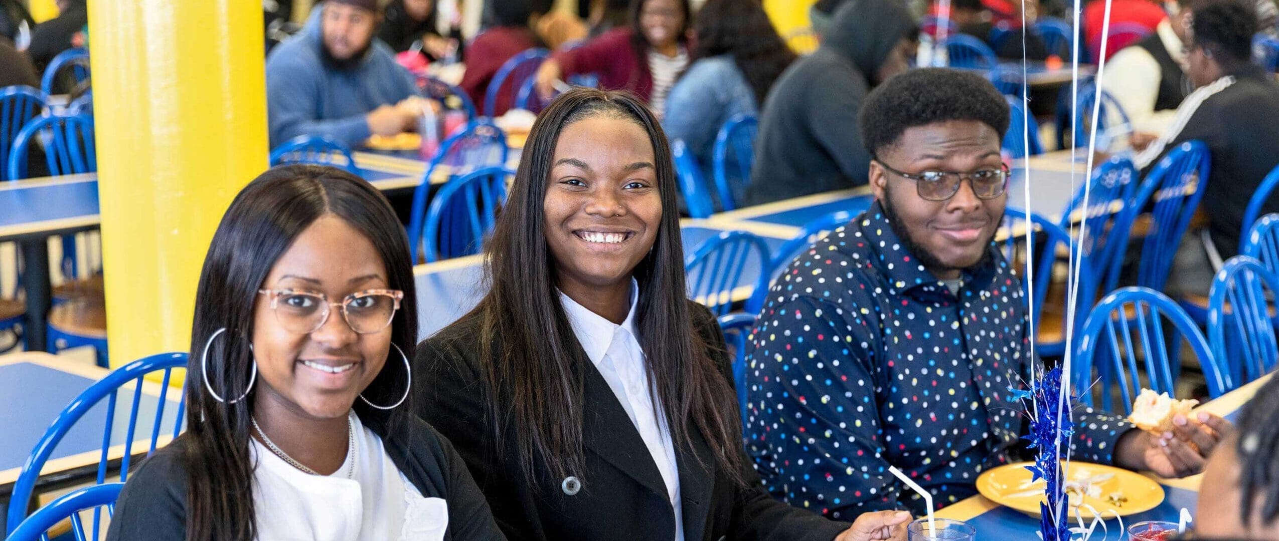 Students sitting at table in cafeteria